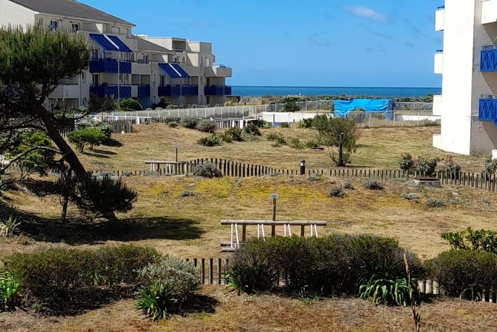 un parc avec une table de pique-nique en face d'un bâtiment dans l'établissement Superbe T2 dans Rés Bleu Marine - Face à l'Ocean, à Lacanau