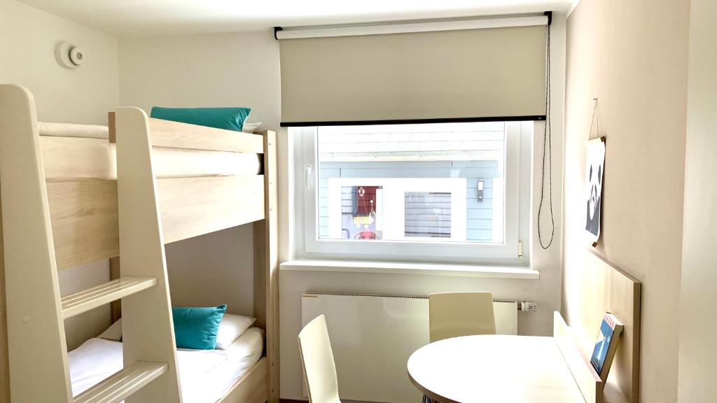 a small room with bunk beds and a window at Apartmenthaus Hohenfels in Helgoland