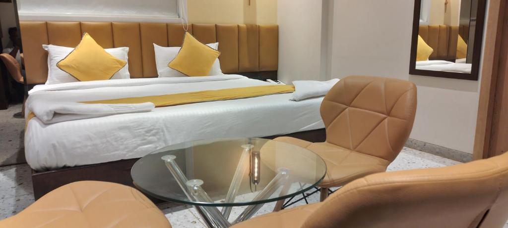 Shine Hospitality Group في مومباي: غرفة فندقية بسرير وطاولة وكراسي