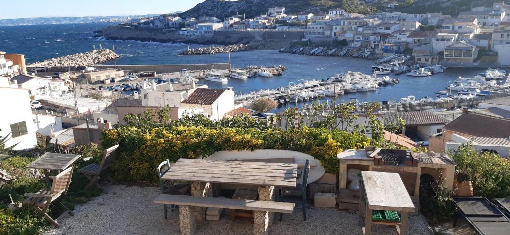 une vue d'un port avec un banc et des bateaux dans l'établissement Cabanon Vue mer et calanques Les Goudes, à Marseille