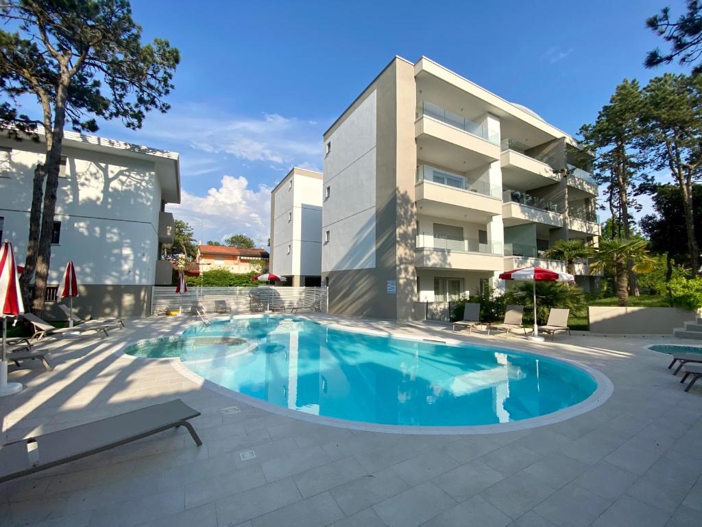 a large swimming pool in front of a building at Residence Melograno in Bibione