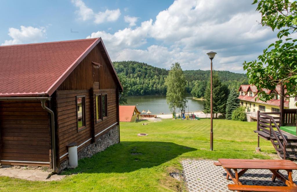 un edificio con una mesa de picnic y un lago en Złoty Potok Resort, en Złoty Potok