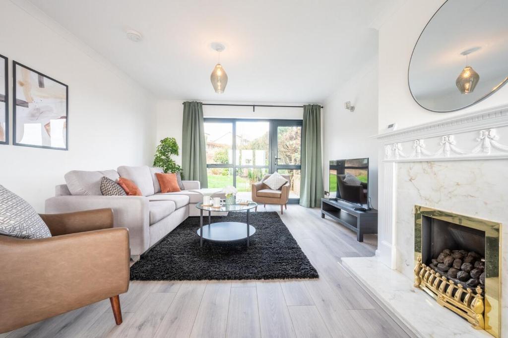 a living room with a couch and a fireplace at Trinity View by Tŷ SA - Beautiful 5 bed in Newport in Caerleon