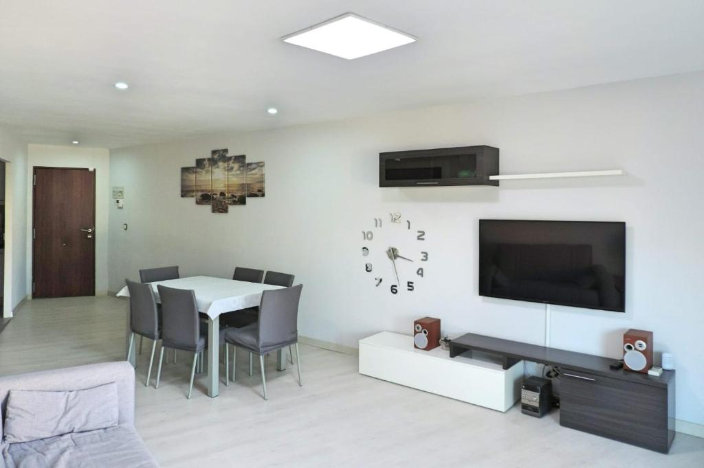 a living room with a dining table and a television at Tu oasis, a la orilla del mar in Salou