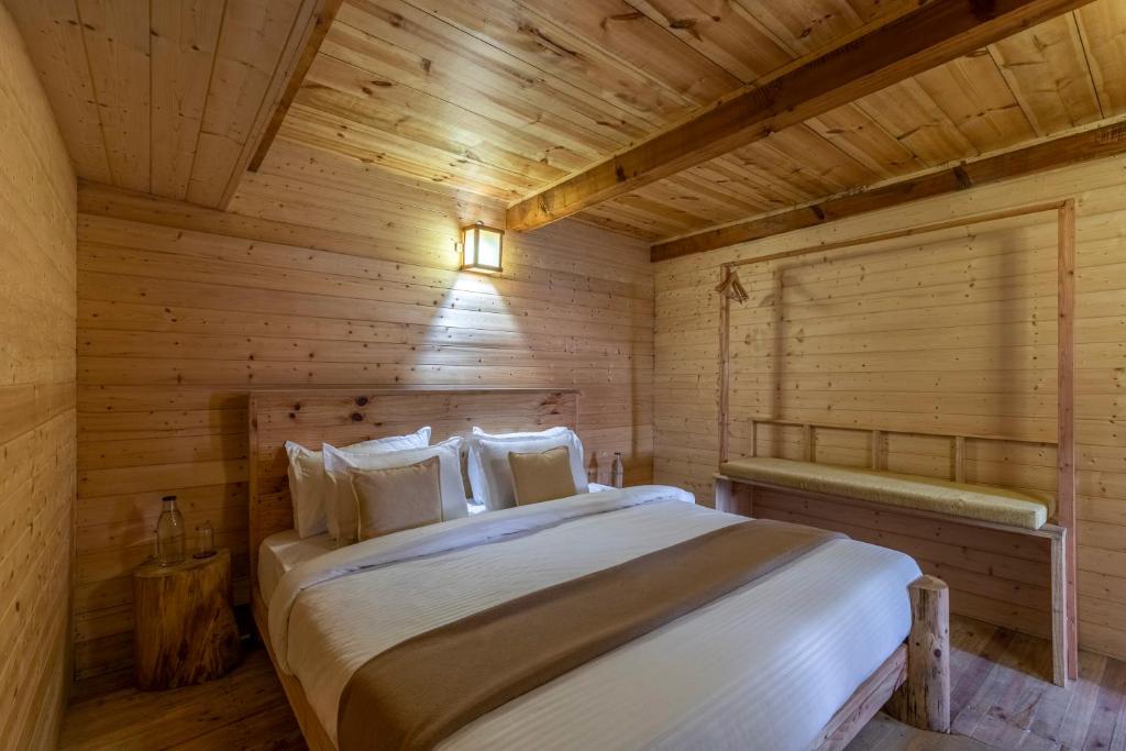 ein Schlafzimmer mit einem Bett in einem Holzzimmer in der Unterkunft Elivaas Everly Luxury 1BHK Entire Home in Narkanda in Shimla