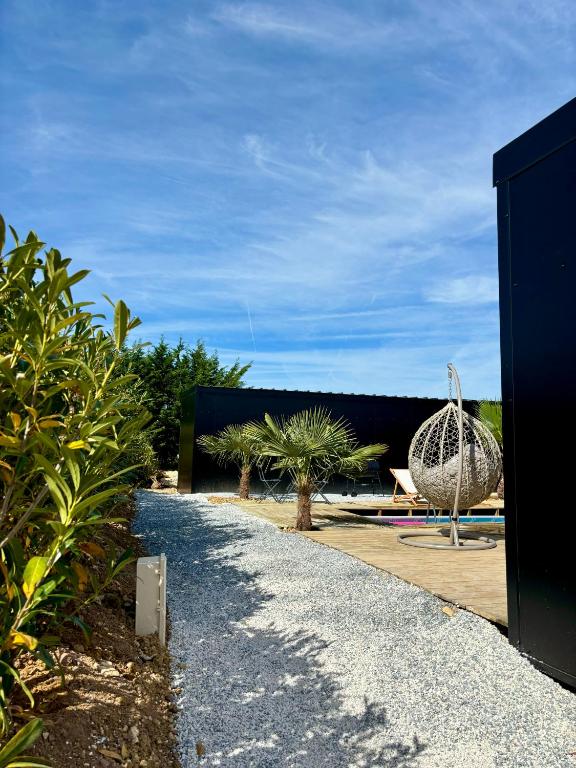 a garden with palm trees and a building at Evasion tropicale in Bretteville-sur-Odon