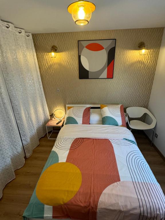 a bedroom with a bed with a colorful blanket at Chambre privée-Clim-TV-Confort-Breakfast inclus in Nevers