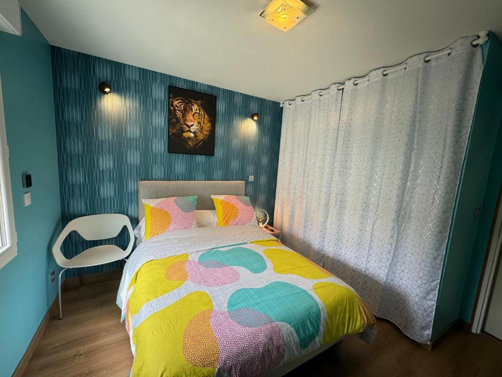 - une chambre avec un lit coloré et une fenêtre dans l'établissement Maison calme/Chambre privée/Clim+TV/Pétit dejeuner inclu/tout confort, à Nevers