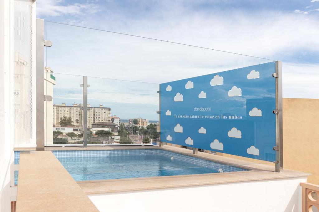 una señal en el lateral de un edificio con piscina en Apartamento Don Algodón Grau, en Los Mártires