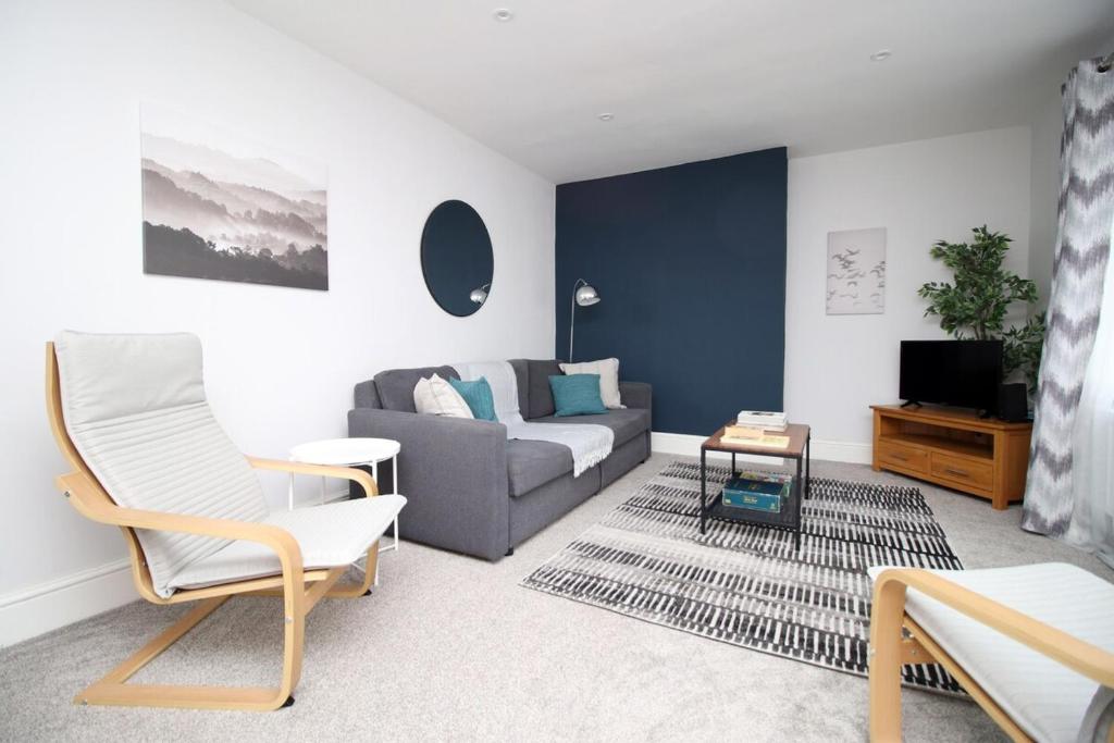 uma sala de estar com um sofá e uma televisão em Willow Way by Tŷ SA em Nantgarw