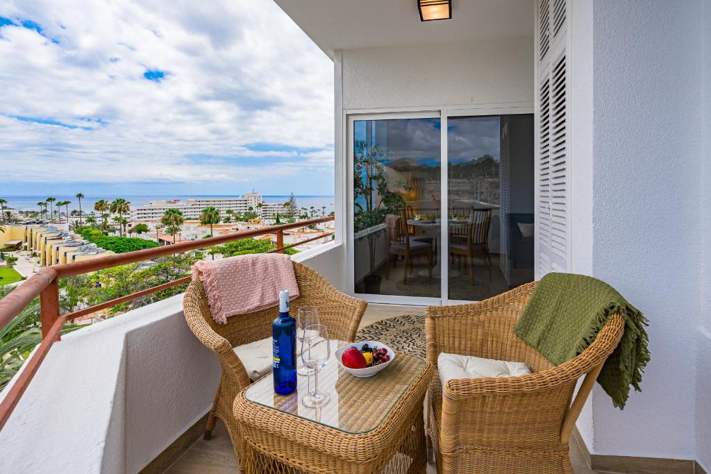 a balcony with a table and chairs with a view of the ocean at GREEN AGAVE by Welcome Tenerife in Playa de las Americas