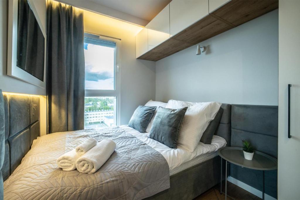 um quarto com uma cama com toalhas em WiguryTower Apartaments 92 em Lódź