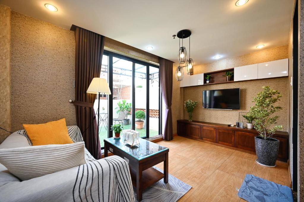 - un salon avec un canapé et une télévision dans l'établissement Amory Apartment Nguyen Trai, à Hô-Chi-Minh-Ville