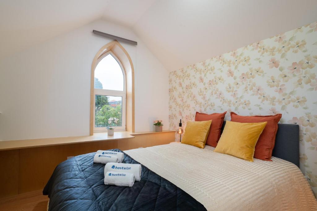 Schlafzimmer mit einem großen Bett und einem Fenster in der Unterkunft Host Wise - Central Duplex House - Terrace in Vila Nova de Gaia