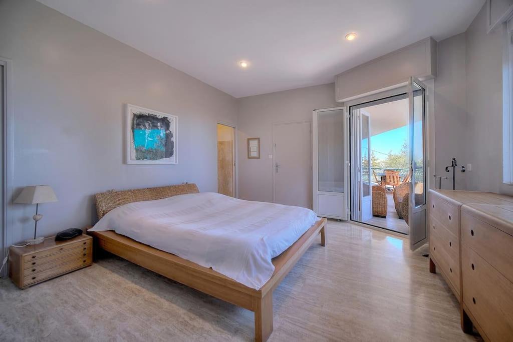 a bedroom with a large bed and a large window at FRGK "Villa Le Petit Bois Vue Panoramique Jardin Verdoyant près de Cannes" in Vallauris