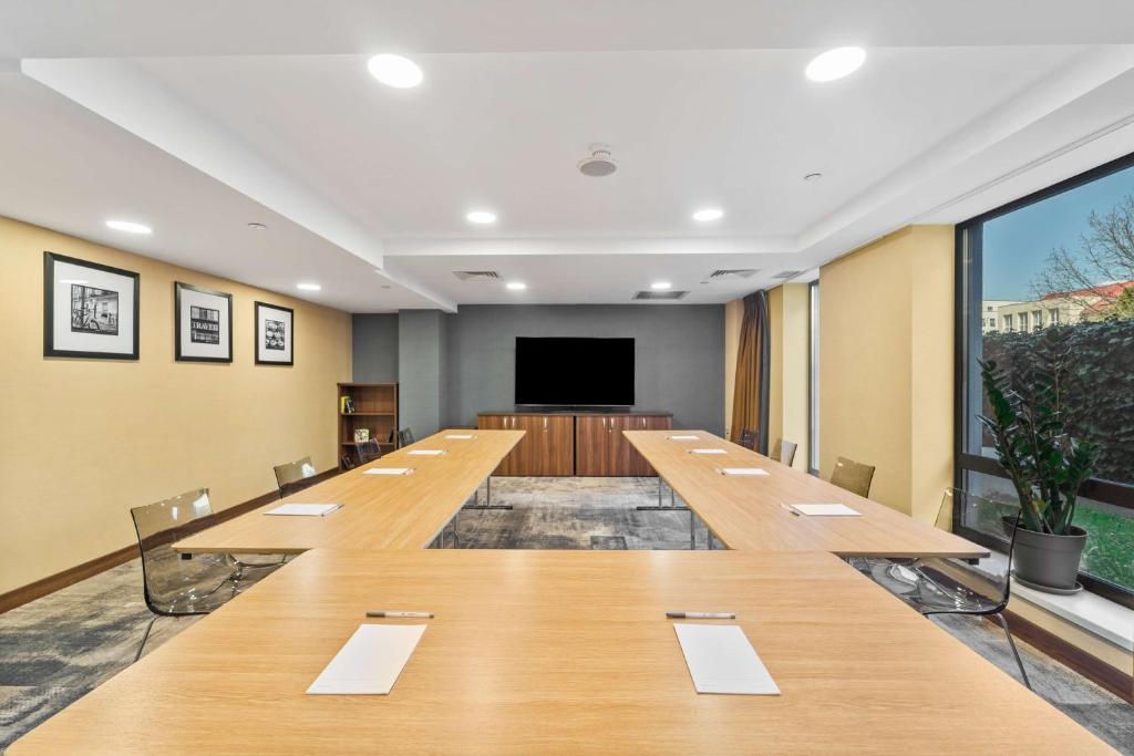 a large conference room with a long table and a screen at Hampton by Hilton Cluj-Napoca in Cluj-Napoca