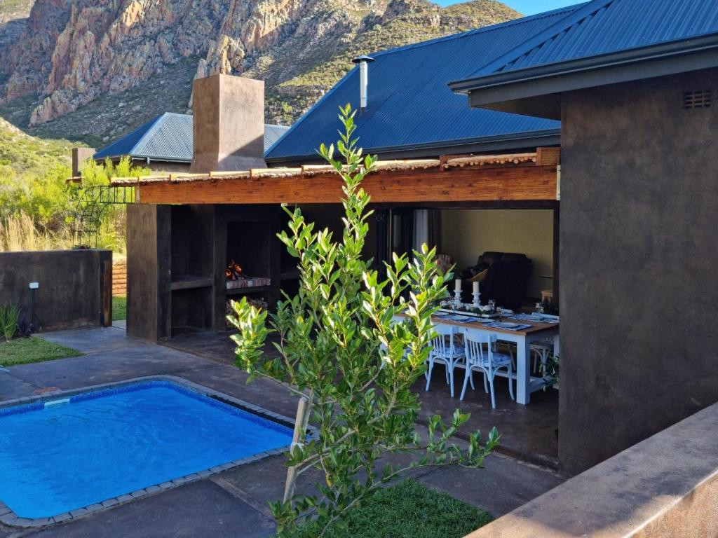 a house with a swimming pool next to a house at Oorlogs Kloof Mountain Retreat Montagu in Montagu