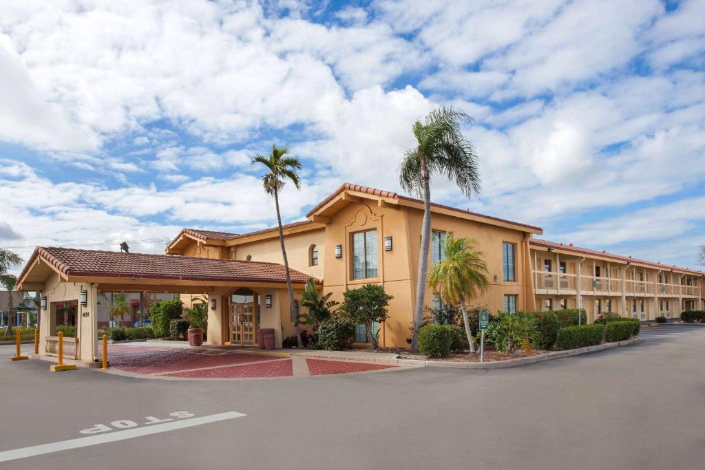 ein Hotel mit Palmen vor einer Straße in der Unterkunft Baymont by Wyndham Fort Myers Central in Fort Myers