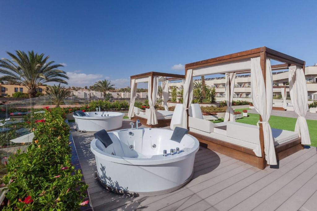 a resort with three bath tubs on a deck at Barceló Corralejo Bay - Adults Only in Corralejo