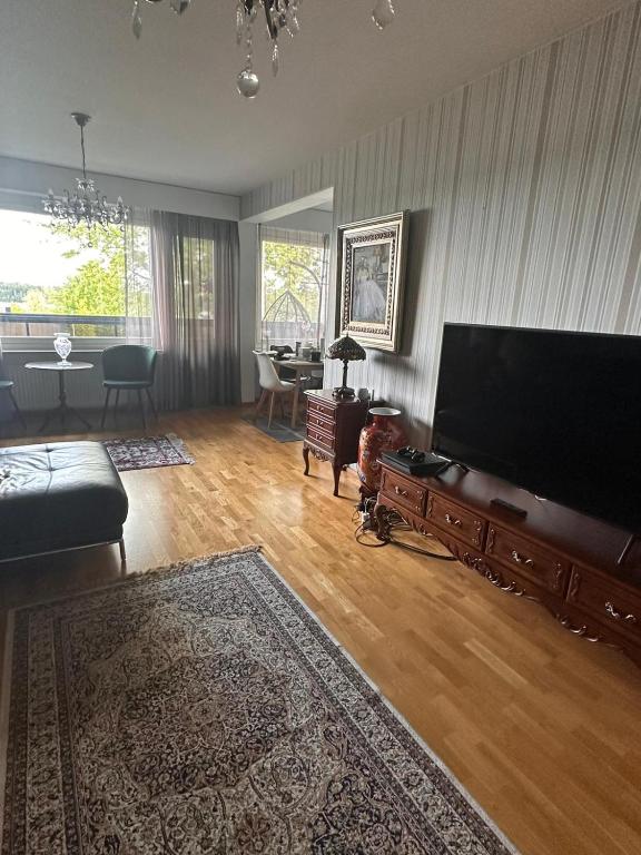 sala de estar con TV de pantalla plana grande en Lakeview central residence, en Savonlinna