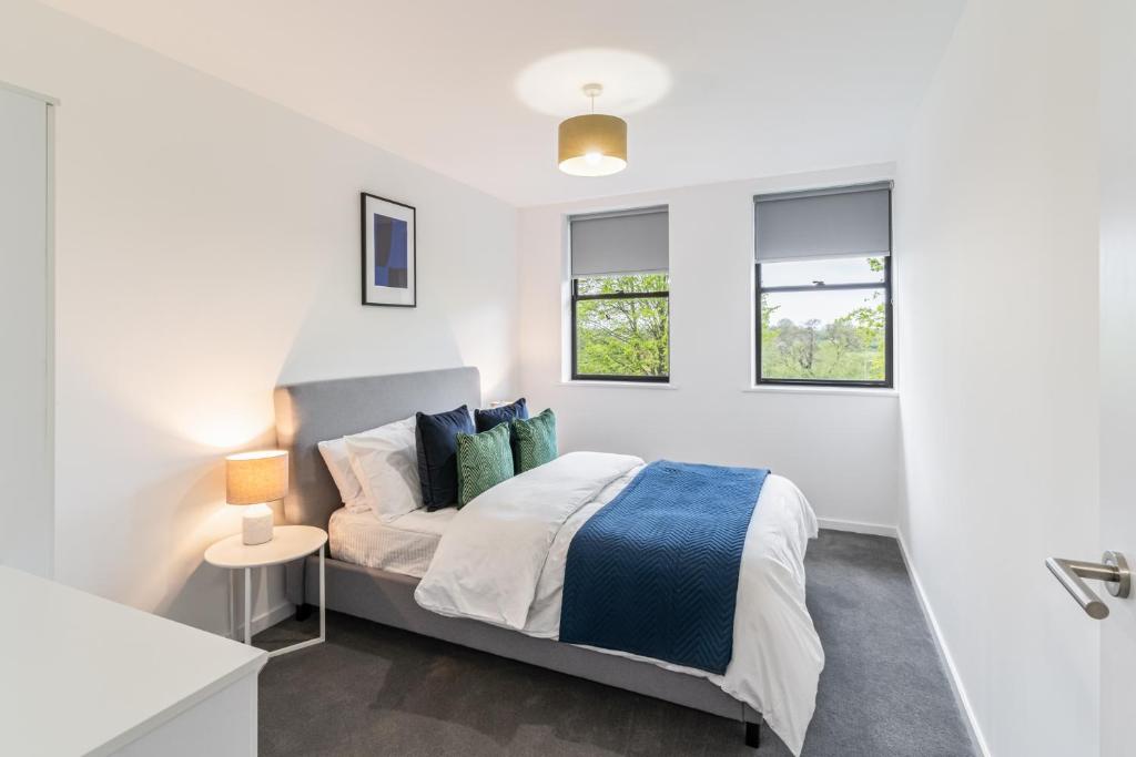 a white bedroom with a bed and two windows at Host & Stay - 36 Waterside Place in Taunton
