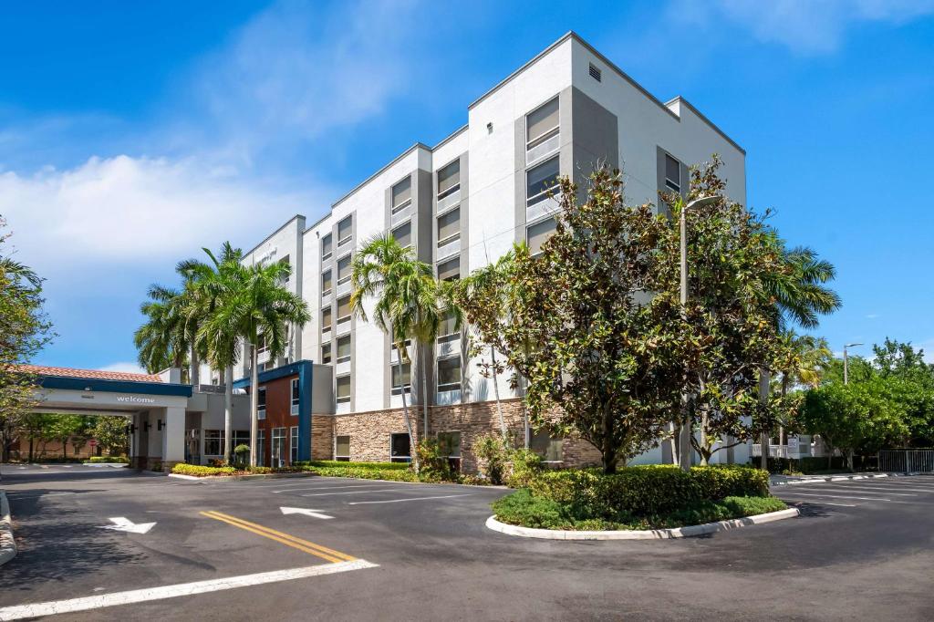 un edificio bianco con palme in un parcheggio di Hampton Inn Weston Fort Lauderdale a Weston