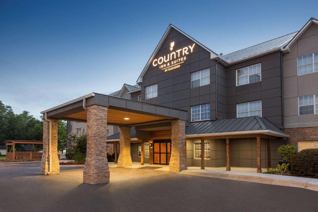 a hotel with a sign on the front of a building at Country Inn & Suites by Radisson, Jackson-Airport, MS in Pearl