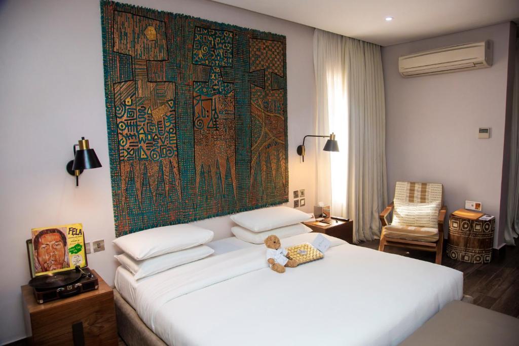 a bedroom with a teddy bear sitting on a bed at The White Orchid Hotel in Lagos