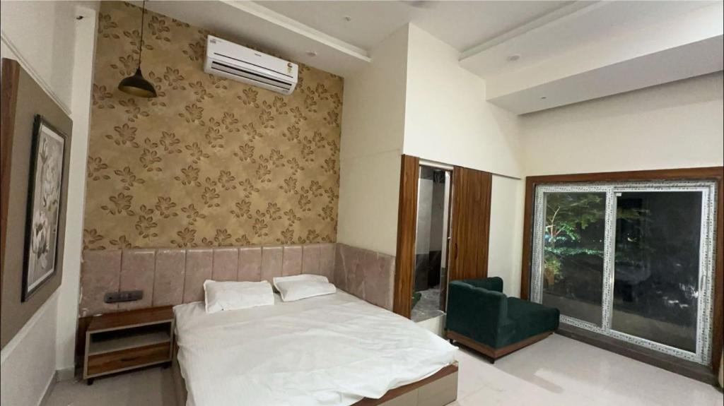 1 dormitorio con cama blanca y ventana en Hotel DC en Bhopal