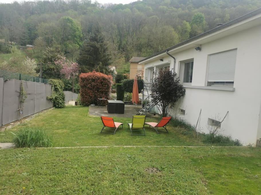 une cour avec trois chaises et une maison dans l'établissement Maison lumineuse & chaleureuse, à Saint-Romain-au-Mont-dʼOr