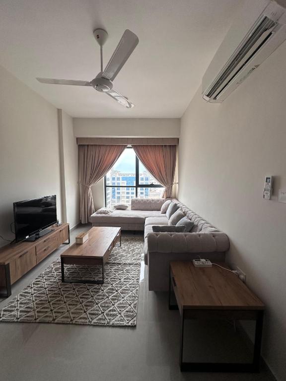 ein Wohnzimmer mit einem Sofa und einem TV in der Unterkunft Muscat Apartments in Muscat