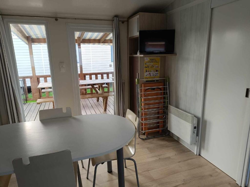 a table and chairs in a room with a kitchen at Mobilhome Caraibes in Oye-Plage