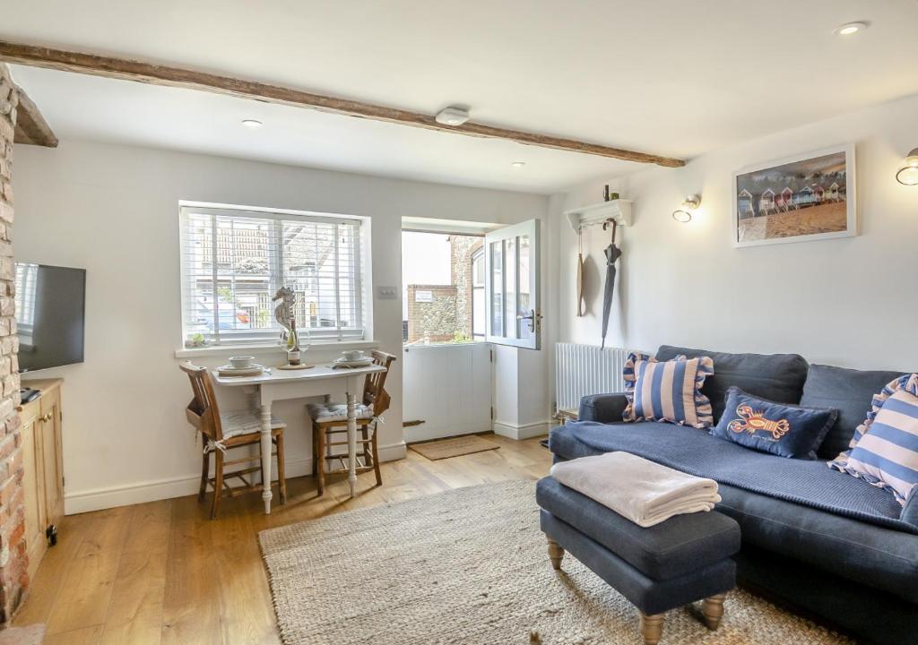 a living room with a blue couch and a table at Fishermans Cottage in Wells next the Sea