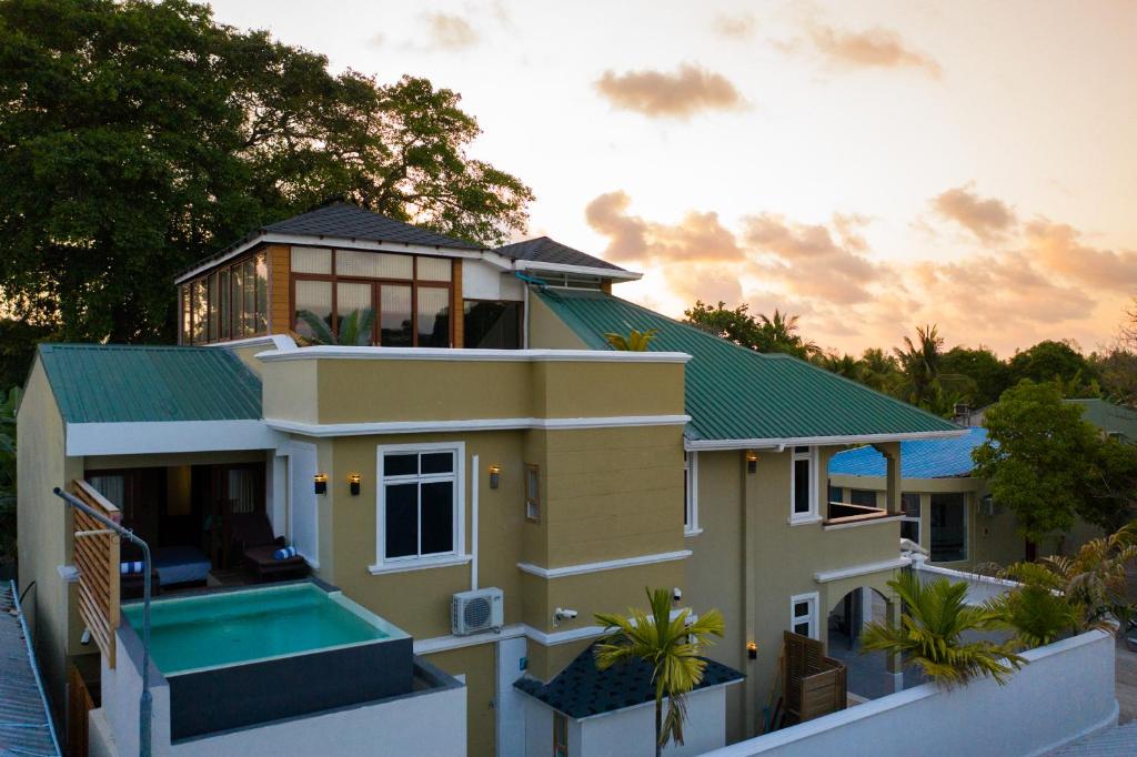 una casa grande con techo verde en Fuvahmulah Central Hotel, en Fuvahmulah