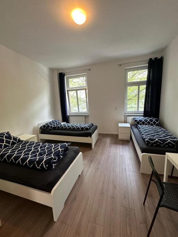 Zimmer mit 3 Betten und 2 Fenstern in der Unterkunft Ar Living Frankfurt Königsteinerstr in Frankfurt am Main