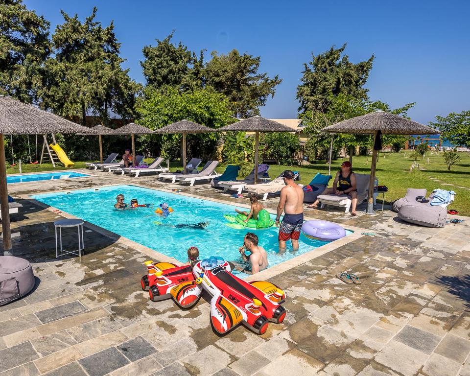 un grupo de personas jugando en una piscina en Let it Be Apartments en Theologos
