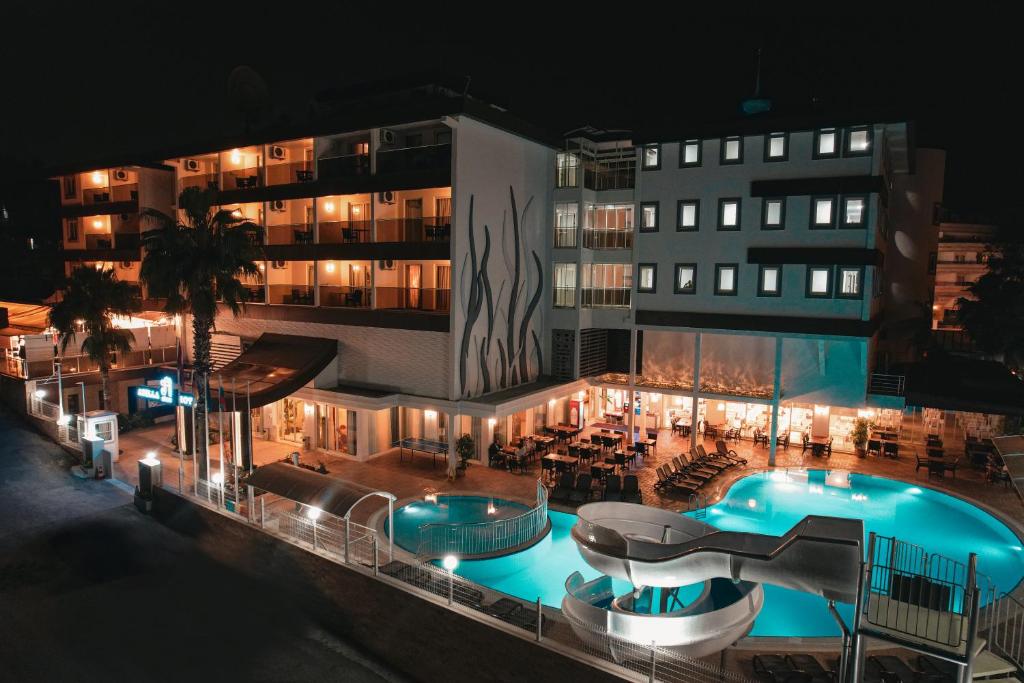 a large building with a swimming pool at night at Adella Side Hotel in Side