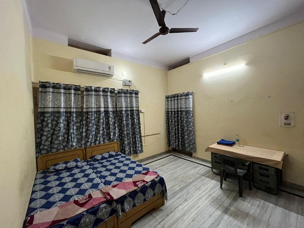 a bedroom with a bed and a desk in it at Vishwa Deva Homestay in Varanasi