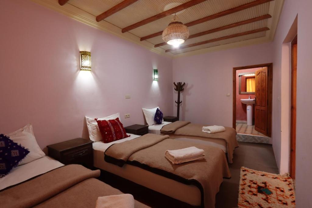 a bedroom with three beds in a room at DAR ATLAS CHARME in Imlil