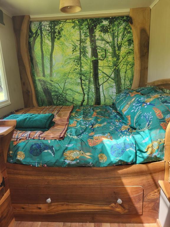 a bedroom with a bed with a painting on the wall at Courtlands farm camping and glamping in Canterbury