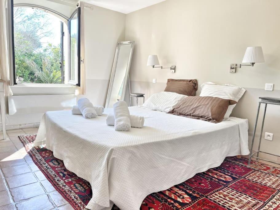 a large white bed in a room with a window at Magnifique villa avec Piscine Vue mer in Sanary-sur-Mer