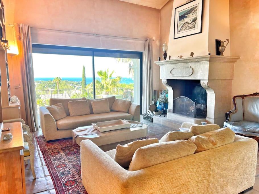 a living room with a couch and a fireplace at Magnifique villa avec Piscine Vue mer in Sanary-sur-Mer