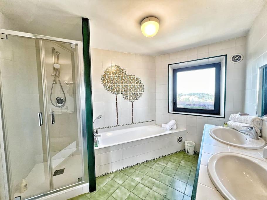 a bathroom with a tub and a shower and a sink at Magnifique villa avec Piscine Vue mer in Sanary-sur-Mer