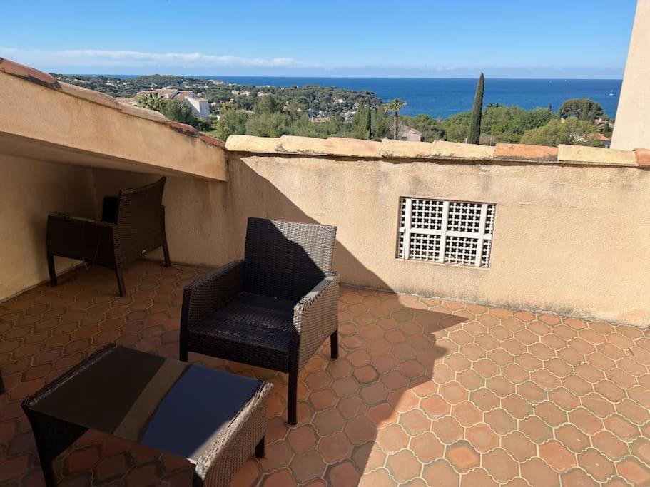 a patio with two chairs and a table on a balcony at Magnifique villa avec Piscine Vue mer in Sanary-sur-Mer