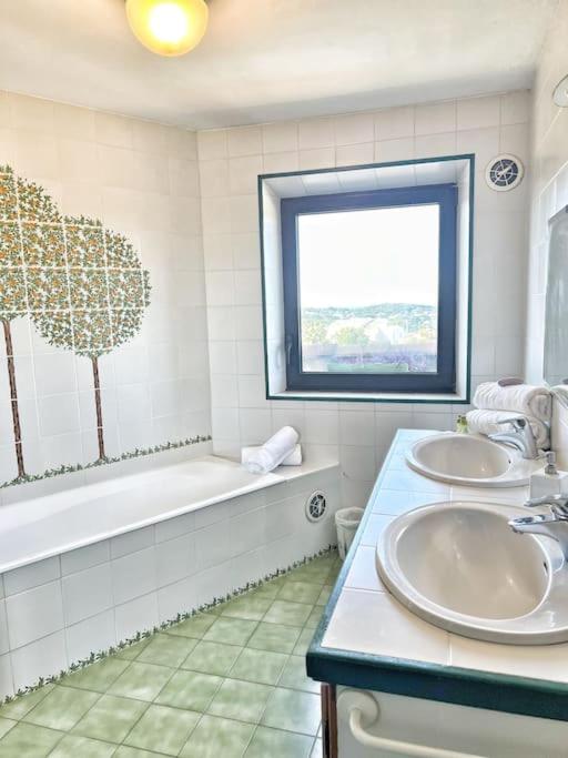 a bathroom with two sinks and a tub and a window at Magnifique villa avec Piscine Vue mer in Sanary-sur-Mer