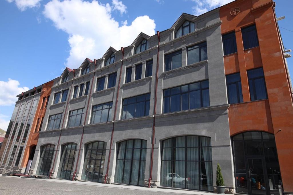 a large building with many windows on a street at BMG Hotel by Grigoryans Group in Goris
