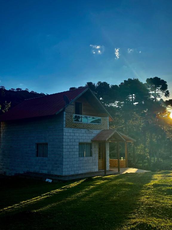 a brick house with a gazebo in a field at Cabanas das Araucárias in Urubici