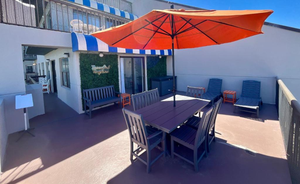 a table and chairs with an umbrella on a balcony at Rooftop Terrace 2 Bedroom Tangerine Suite - Perfect View, Central Location in Orlando