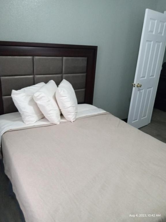 1 cama con sábanas blancas y almohadas en una habitación en Homes -N - Courts en Sanford