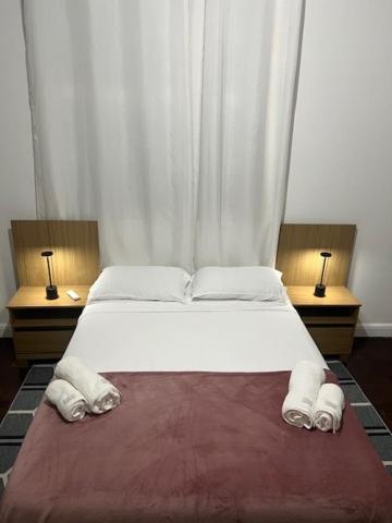 1 dormitorio con 1 cama grande y 2 mesitas de noche en Casa Aconchegante-Rio de janeiro, en Río de Janeiro